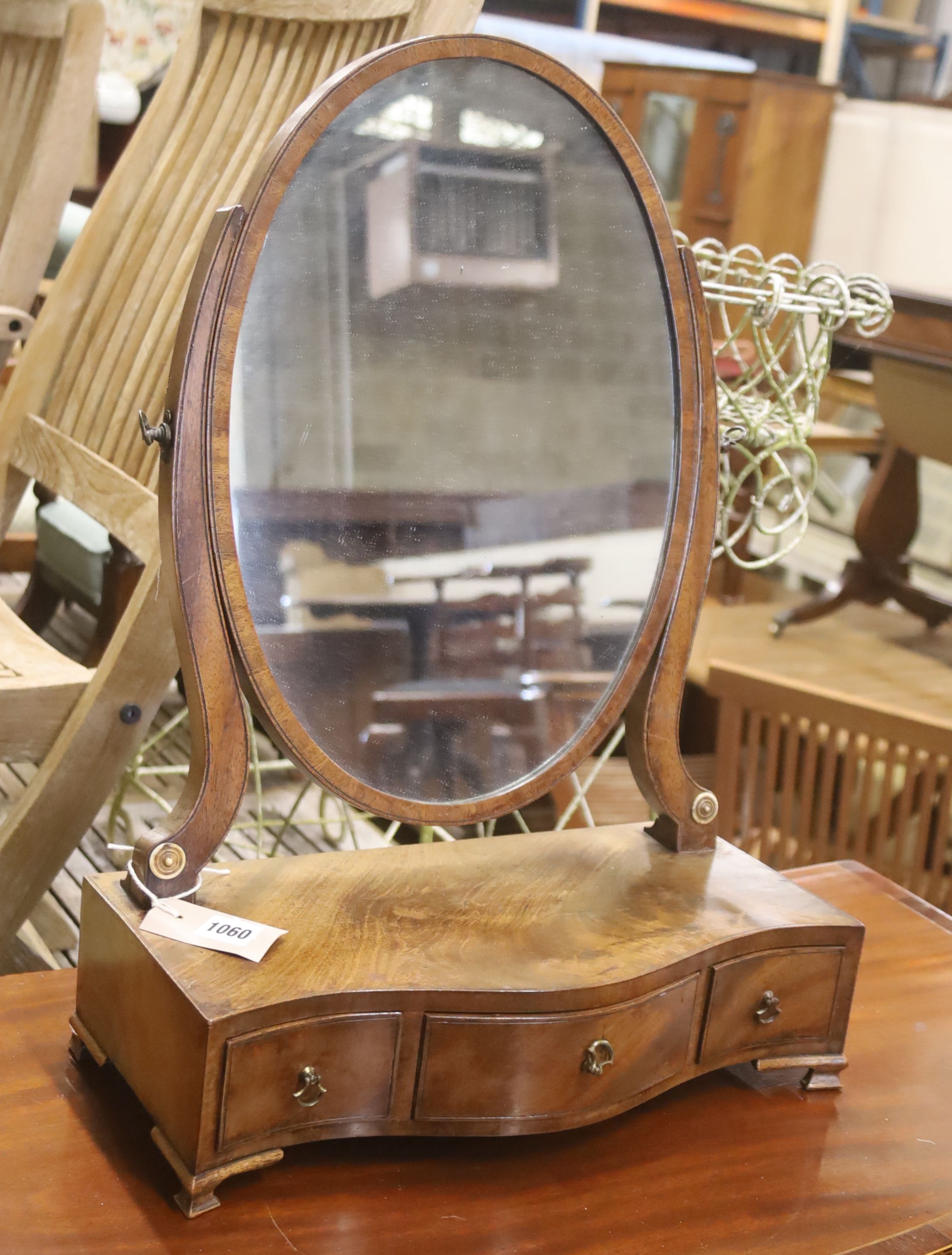 A George III mahogany serpentine toilet mirror, width 42cm, depth 22cm, height 57cm